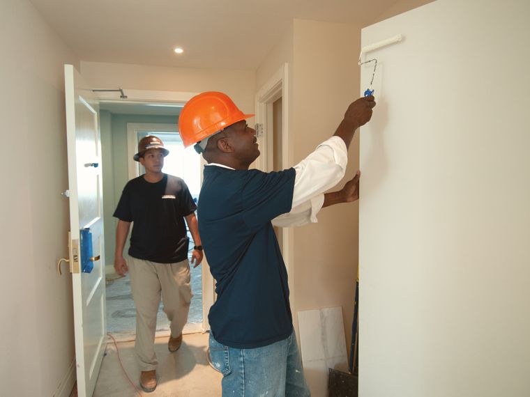 Top Rising crew painting interior walls on site